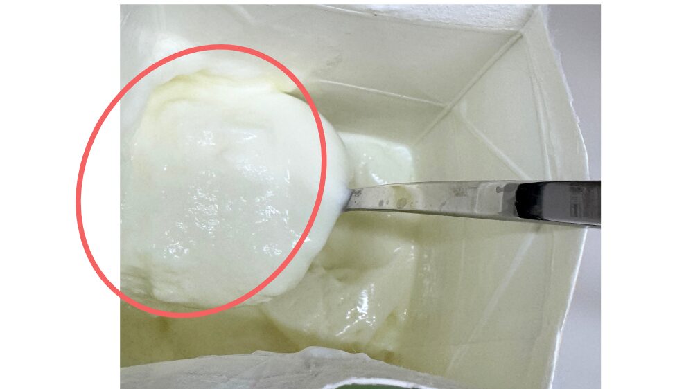 牛乳パックのヨーグルトをすくう様子